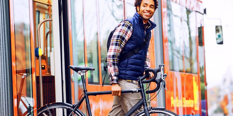 自転車を持って歩く男性